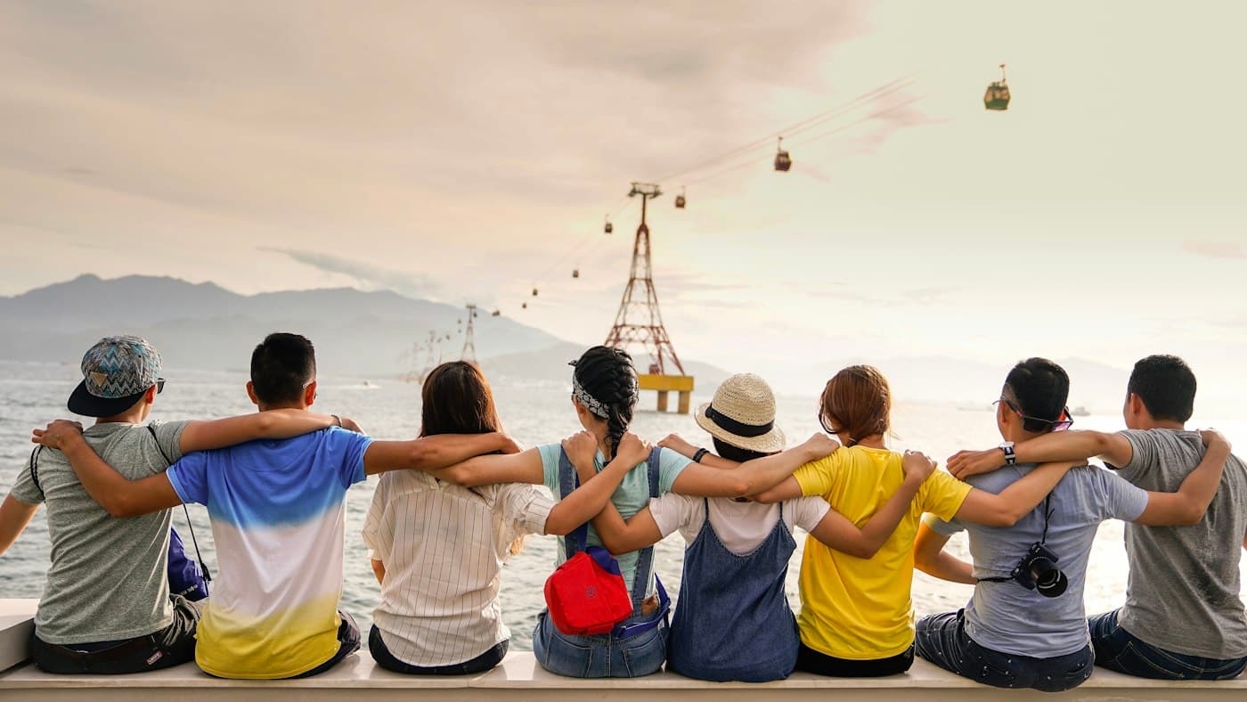 Đội ngũ ngồi quay lưng, khoác vai nhau nhìn ra biển